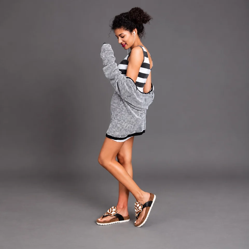 Woman wearing beaded cork-footbed sandals with a striped top and grey cardigan